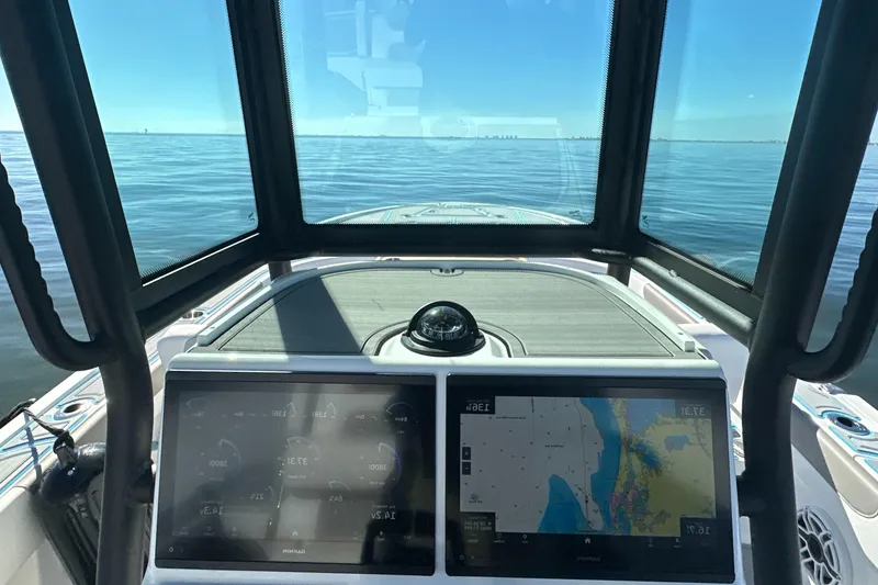 Slide: The Image of 2024 Caymas 281 HB boat dashboard with navigation screens, cruising on open water. - 27
