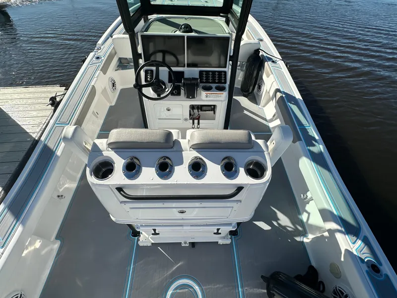 Slide: The Image of 2024 Caymas 281 HB boat interior with console and seating, docked on calm water. - 4