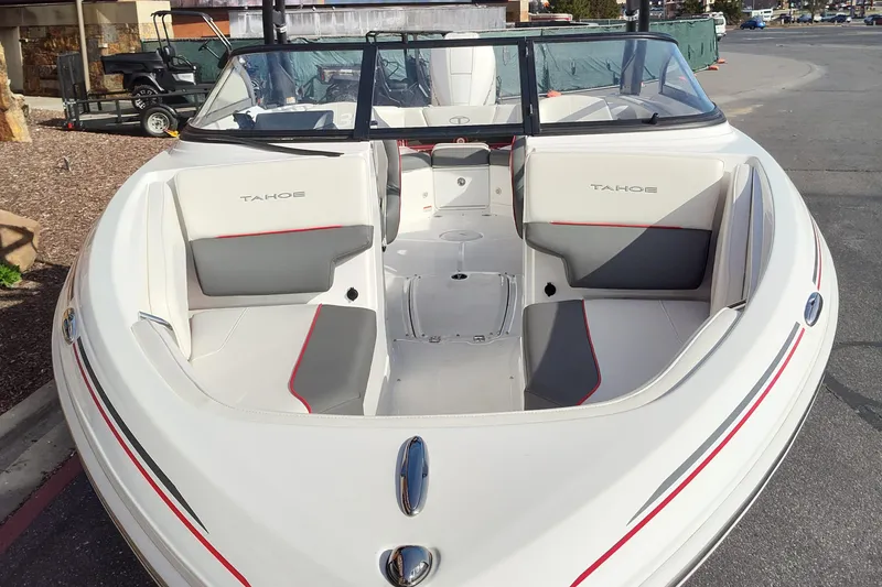 Slide: The Image of 2023 Tahoe 210S boat with white and gray interior, docked. - 1