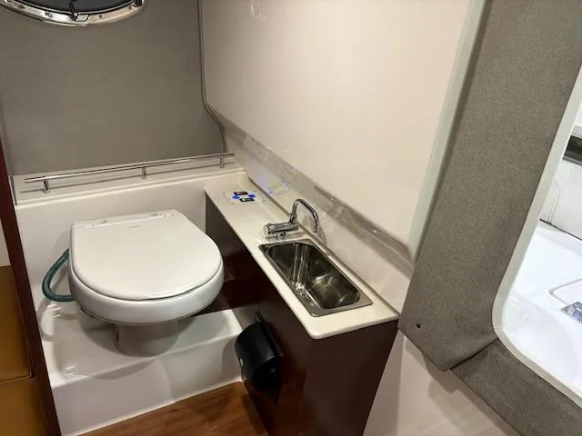 Slide: The Image of 2024 Chaparral 310 OSX boat bathroom with toilet and sink. - 11