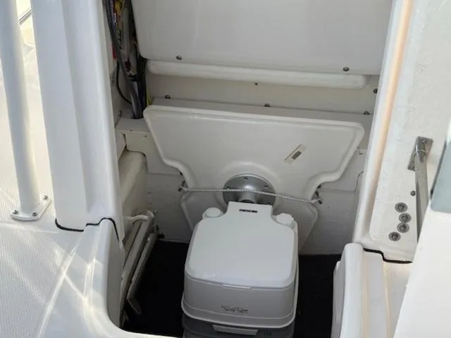 Slide: The Image of 2024 Robalo R202EX boat interior with compact marine toilet. - 11