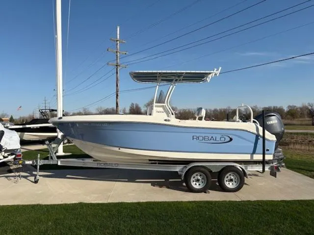 Slide: The Image of 2024 Robalo R202EX boat with Yamaha engine on trailer, parked outdoors. - 2