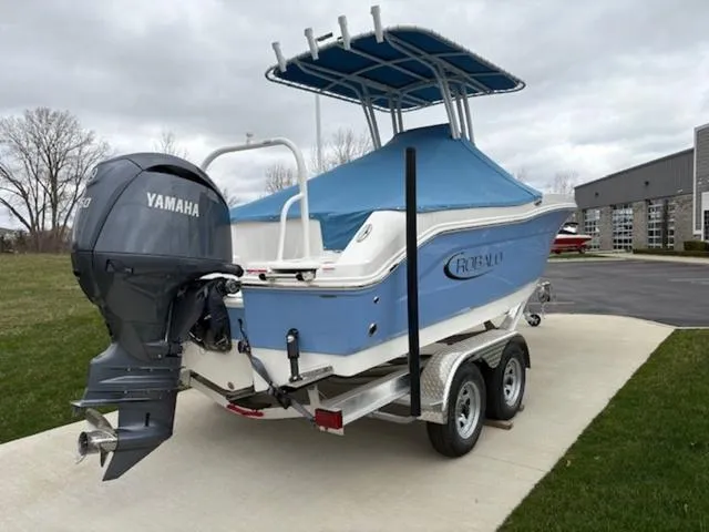 Slide: The Image of 2024 Robalo R202EX boat on trailer, blue cover, parked on concrete driveway. - 4