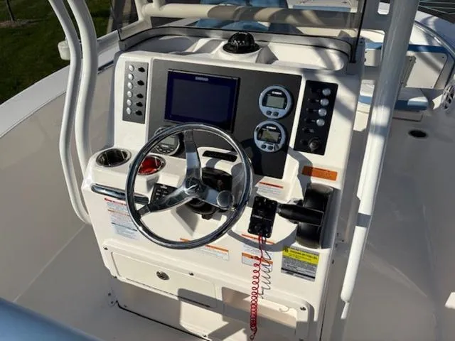 Slide: The Image of 2024 Robalo R202EX boat dashboard with steering wheel and navigation controls. - 6