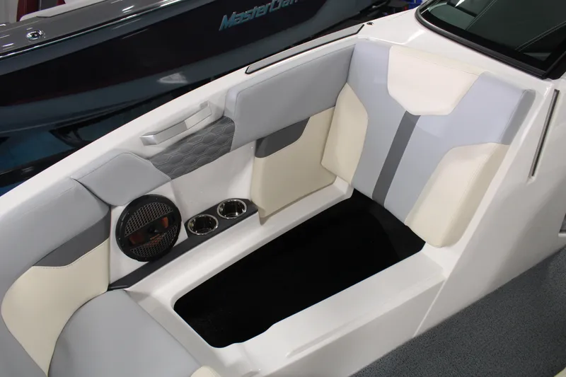 Slide: The Image of 2024 MasterCraft XT24 boat interior with cushioned seating and built-in speakers. - 12