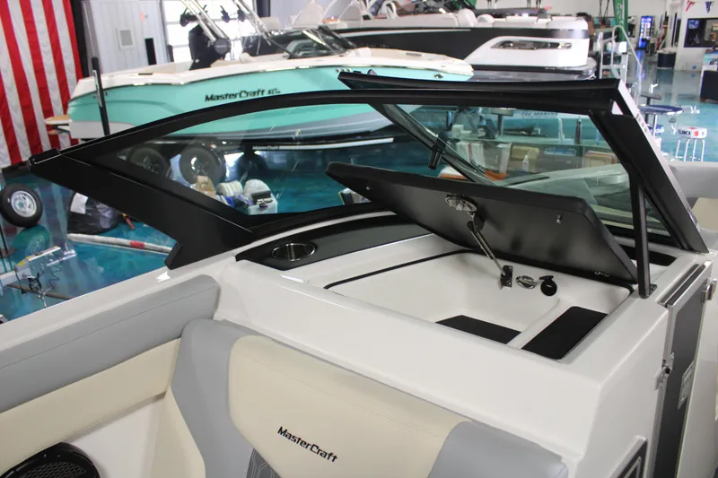 Slide: The Image of 2024 MasterCraft XT24 boat interior with open storage compartment and seating. - 13