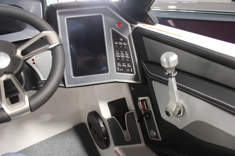 Slide: The Image of 2024 MasterCraft XT24 boat dashboard with touchscreen, steering wheel, and control lever. - 17
