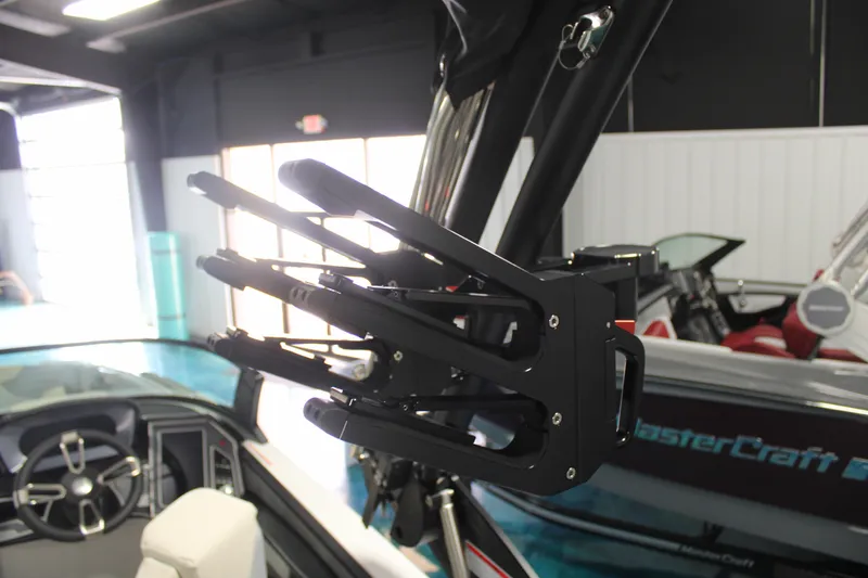 Slide: The Image of 2024 MasterCraft XT24 boat with a wakeboard rack in a showroom. - 22