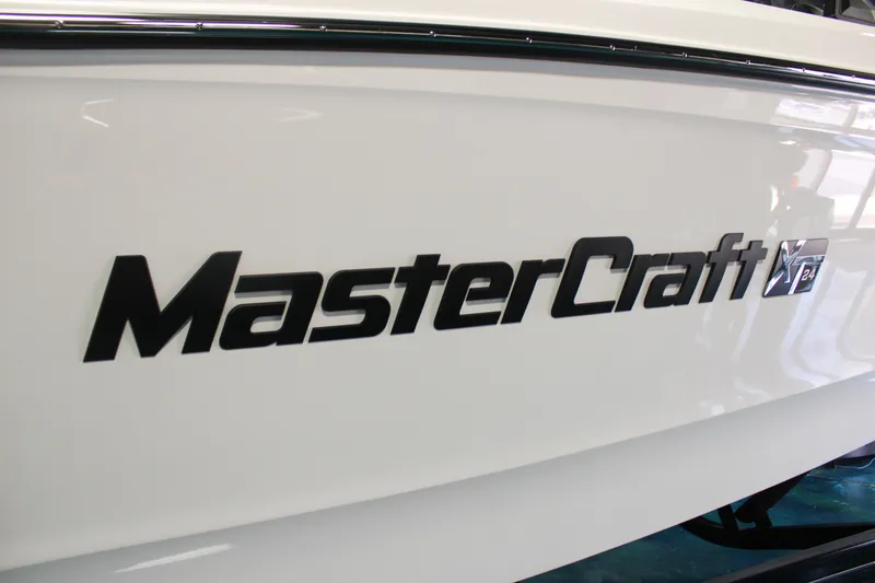 Slide: The Image of 2024 MasterCraft XT24 boat logo on white hull. - 3