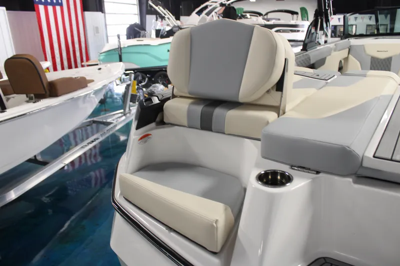 Slide: The Image of 2024 MasterCraft XT24 boat interior with cushioned seating and cup holder. - 31