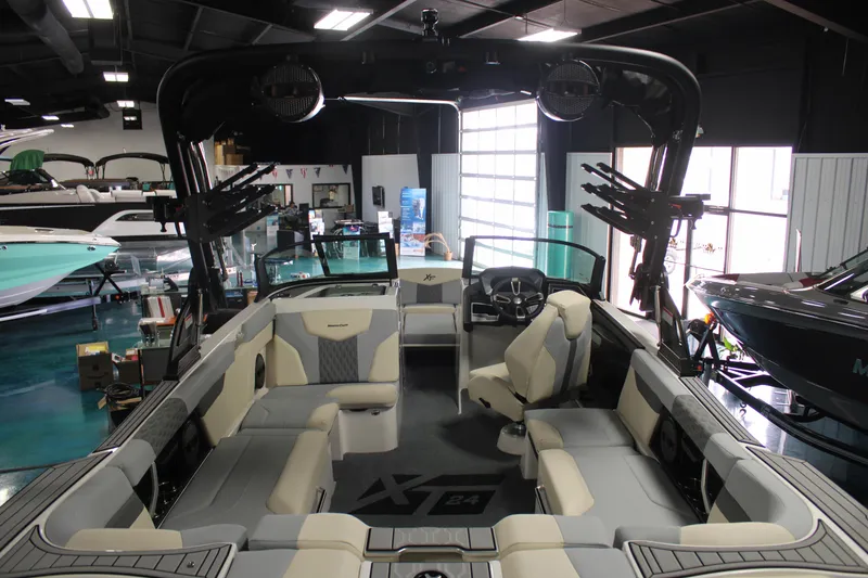 Slide: The Image of 2024 MasterCraft XT24 boat interior with spacious seating and modern design in showroom. - 33