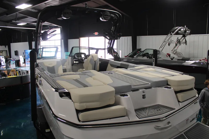 Slide: The Image of 2024 MasterCraft XT24 boat with spacious seating in a showroom. - 5