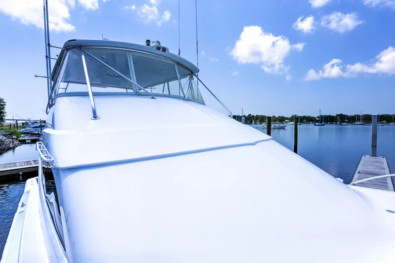 Slide: The Image of 2007 Hatteras 68 Convertible yacht docked under a clear blue sky. - 14
