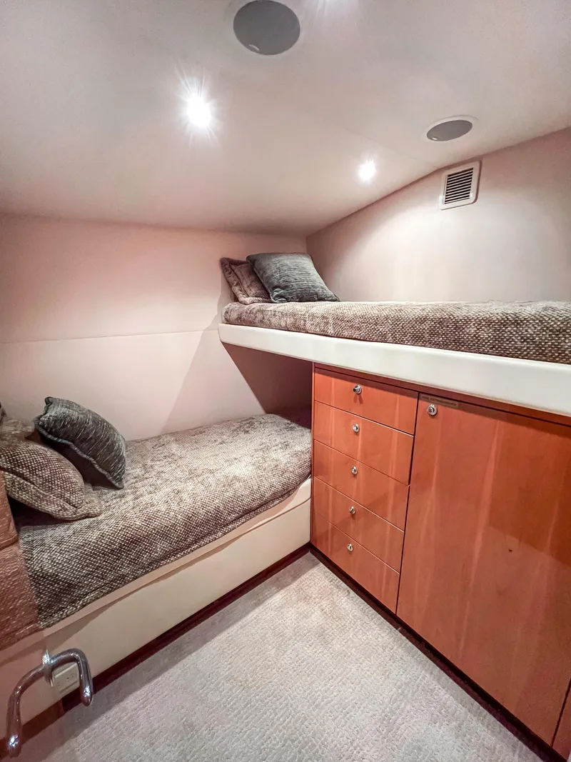 Slide: The Image of Cozy cabin interior of 2007 Hatteras 68 Convertible yacht with bunk beds and wooden cabinetry. - 28