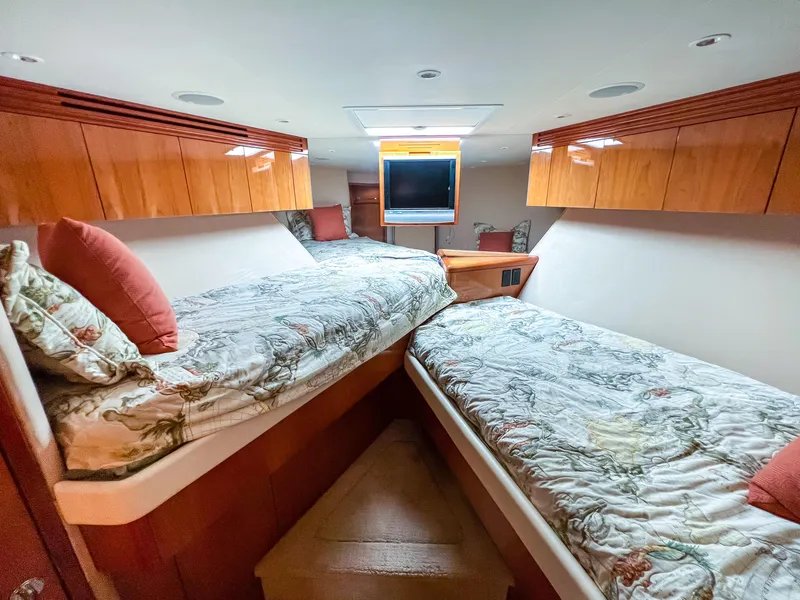 Slide: The Image of 2007 Hatteras 68 Convertible yacht cabin with twin beds and wooden cabinetry. - 32