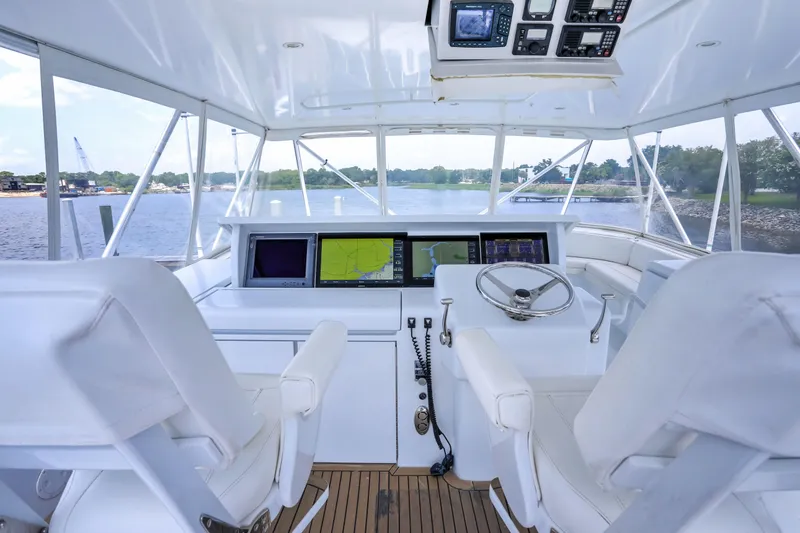 Slide: The Image of Helm of 2007 Hatteras 68 Convertible yacht with modern navigation equipment and white seating. - 5