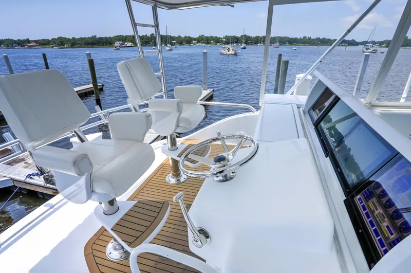 Slide: The Image of 2007 Hatteras 68 Convertible yacht helm with dual captain chairs and scenic water view. - 7