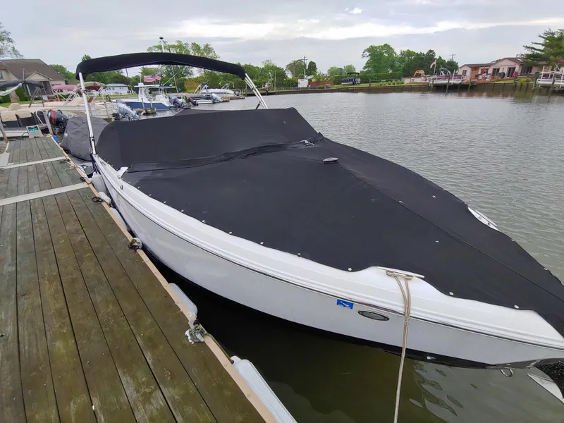 Slide: The Image of 2016 Cobalt R5 boat docked at a marina with a black cover. - 1