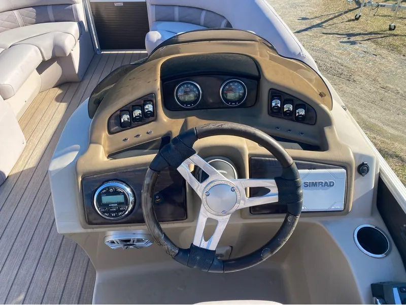 Slide: The Image of 2017 Bennington 22 GSR boat dashboard with steering wheel, gauges, and Simrad display. - 12
