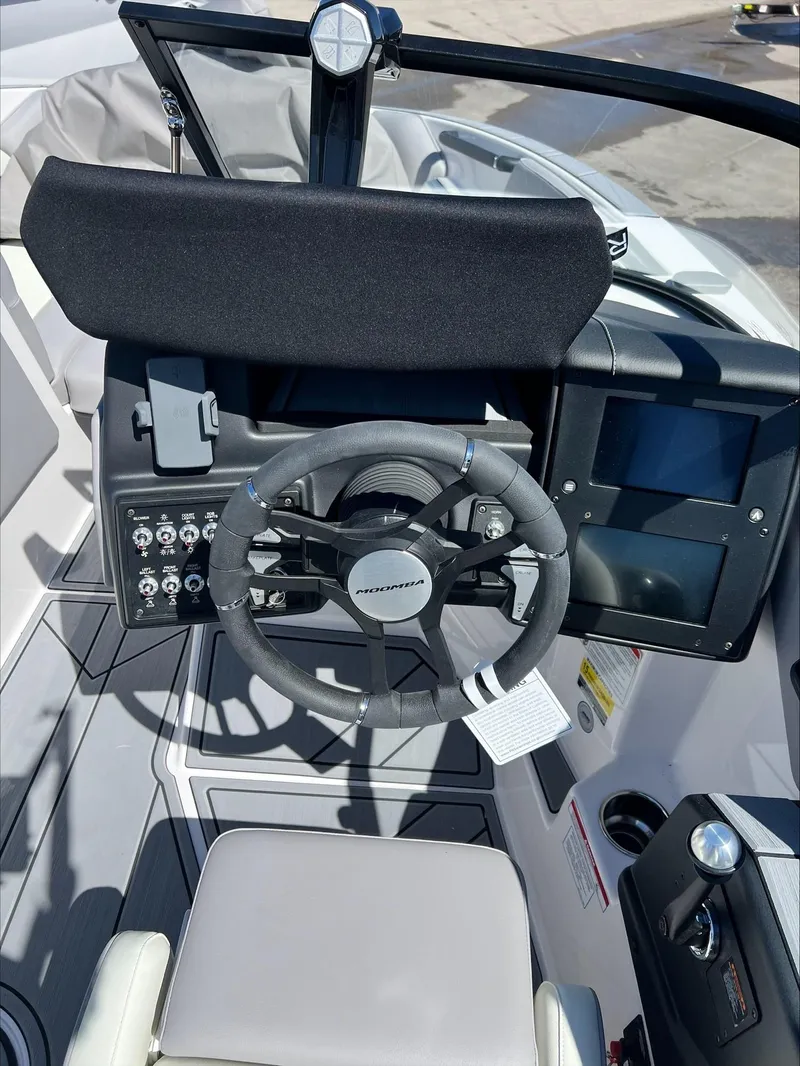 Slide: The Image of 2024 Moomba Craz boat dashboard with steering wheel and control panel. - 10