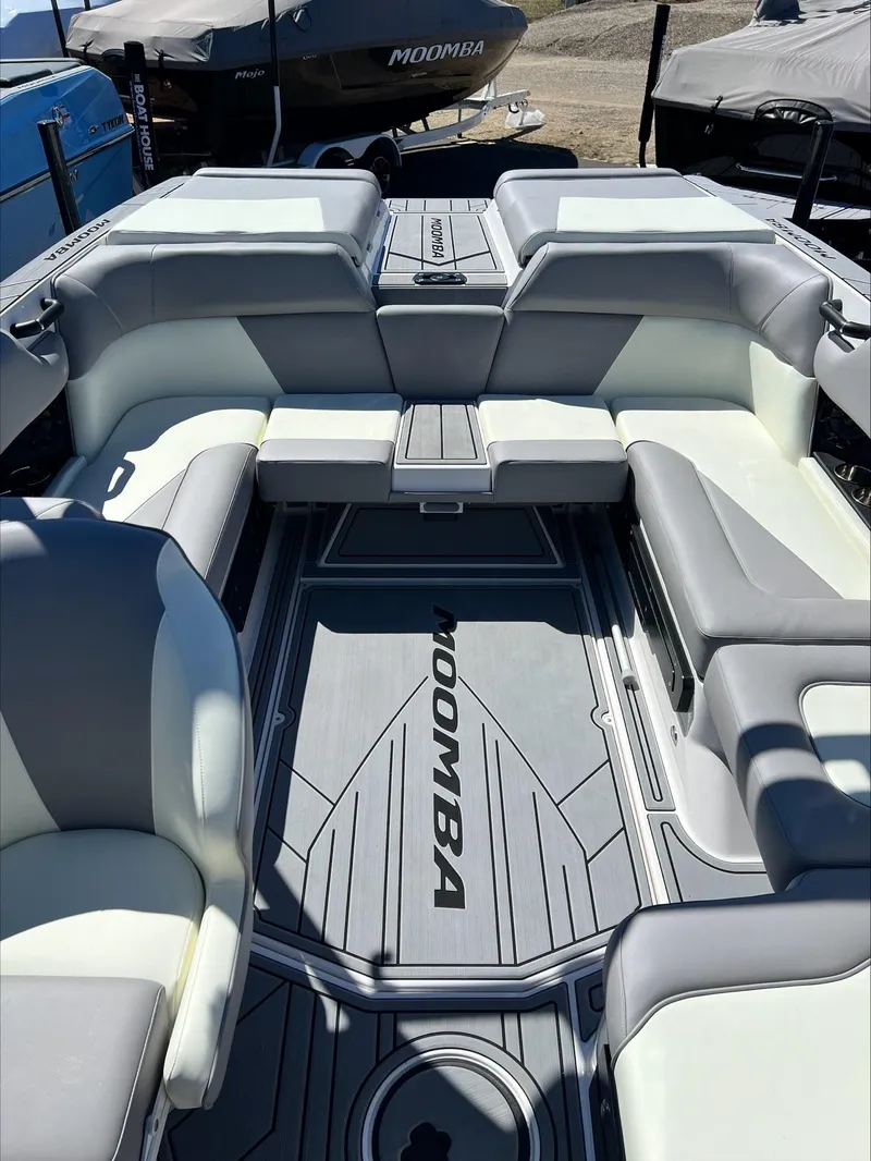 Slide: The Image of 2024 Moomba Craz boat interior with gray and white seating and Moomba-branded flooring. - 5