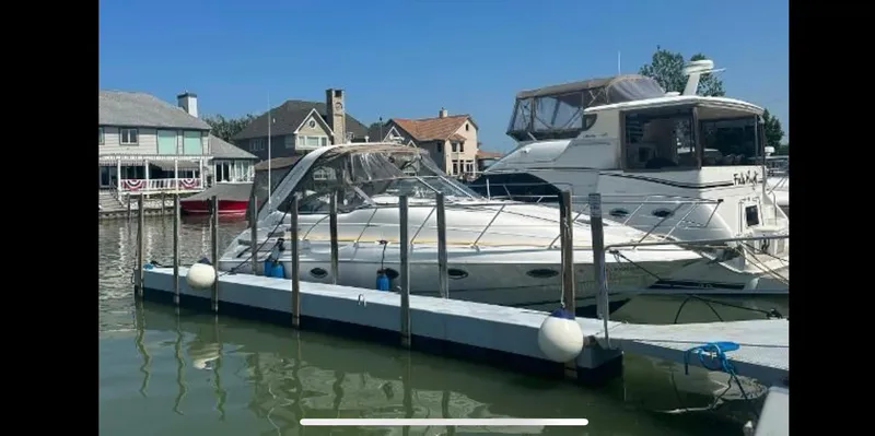 Slide: The Image of 2001 Doral 330se boat docked in a marina with waterfront homes in the background. - 23