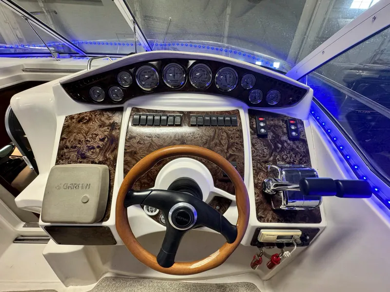 Slide: The Image of 2001 Doral 330se boat dashboard with wood trim, steering wheel, and control panel. - 9
