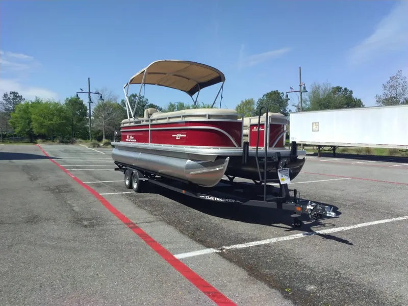 Slide: The Image of 2024 Sun Tracker Party Barge 24 DLX pontoon boat on trailer in parking lot. - 5