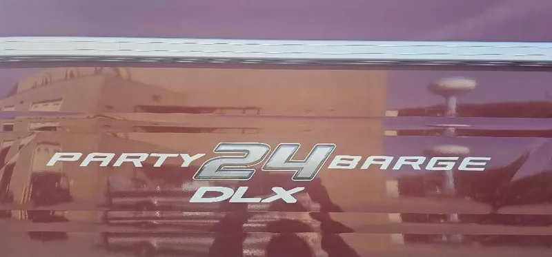 Slide: The Image of 2024 Sun Tracker Party Barge 24 DLX logo on boat exterior. - 4