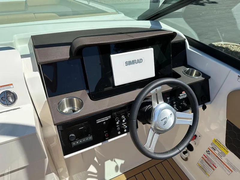 Slide: The Image of 2024 Sea Ray SDX 250 boat dashboard with Simrad display and steering wheel. - 16