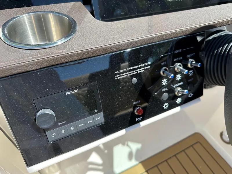 Slide: The Image of Control panel of 2024 Sea Ray SDX 250 boat with cup holder and Fusion audio system. - 18