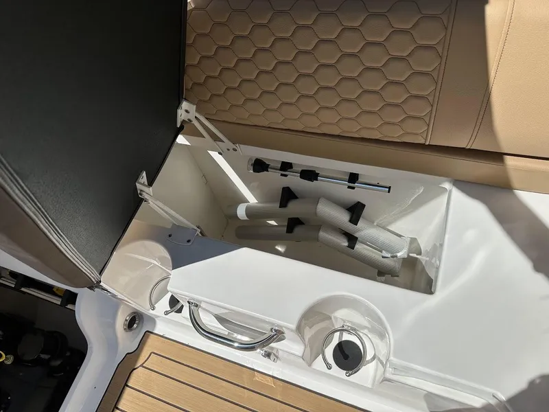 Slide: The Image of Storage compartment in 2024 Sea Ray SDX 250 boat with beige seating. - 23