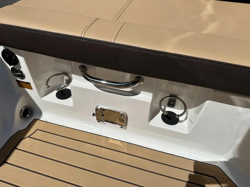 Slide: The Image of 2024 Sea Ray SDX 250 boat seating area with cup holders and teak flooring. - 24