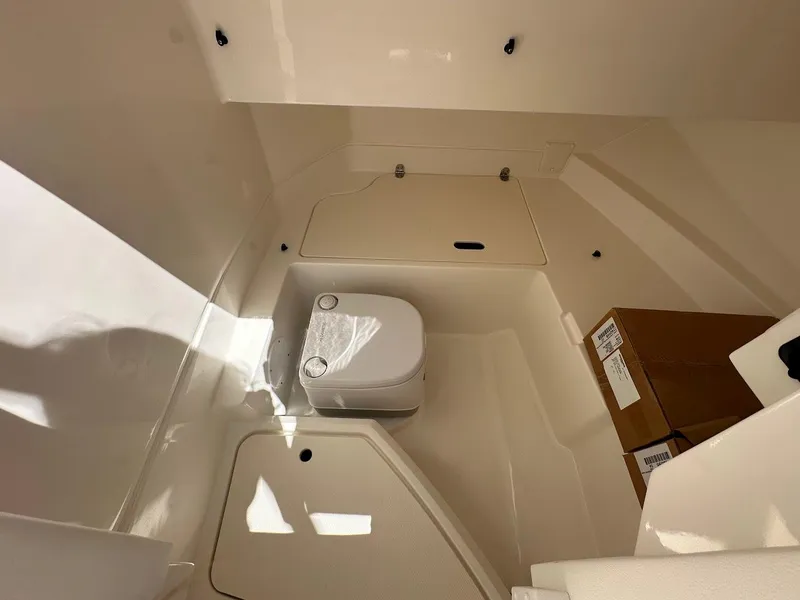Slide: The Image of 2024 Sea Ray SDX 250 boat interior with toilet and storage area. - 30