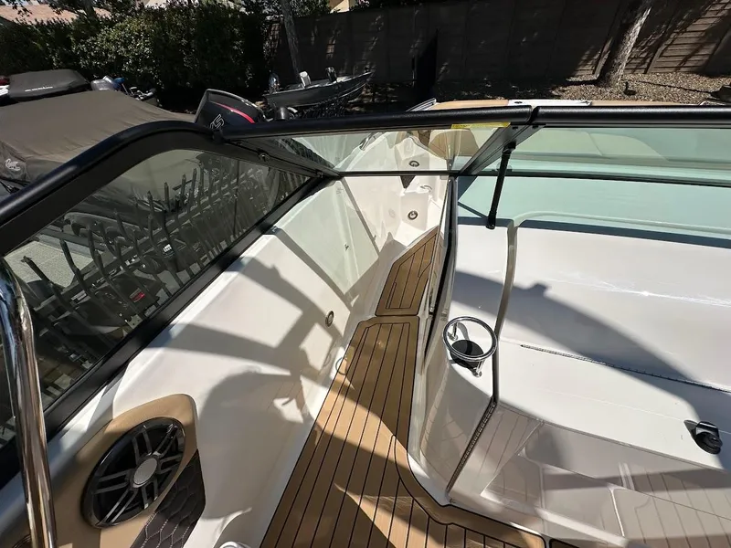 Slide: The Image of 2024 Sea Ray SDX 250 boat interior with teak flooring and glass windshield. - 31