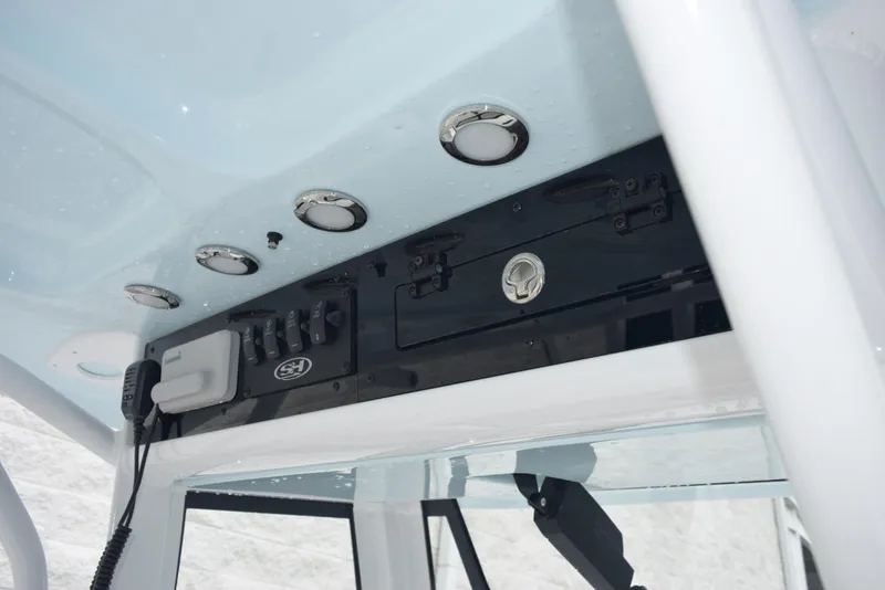 Slide: The Image of 2024 Sea Hunt Escape 27 boat console with controls and storage compartments. - 13