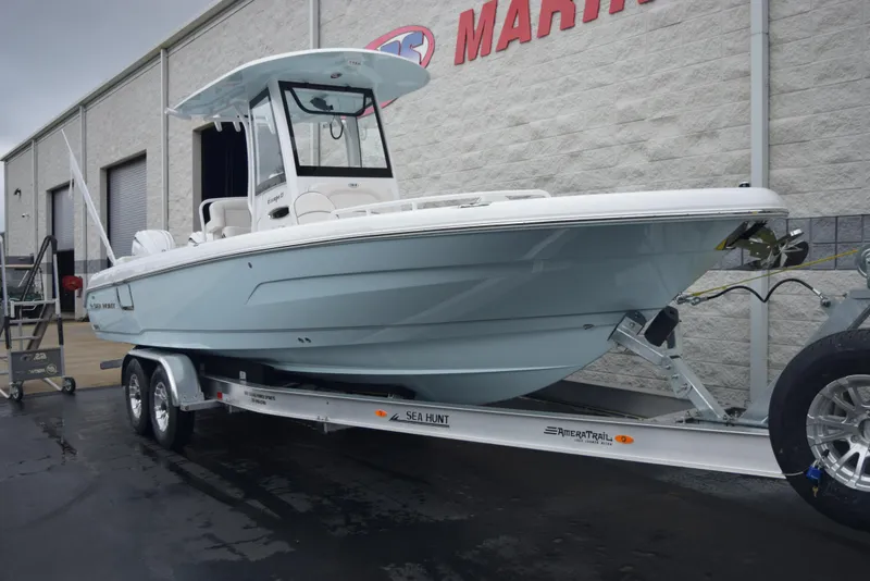 Slide: The Image of 2024 Sea Hunt Escape 27 boat on trailer outside marine dealership. - 2