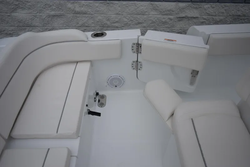 Slide: The Image of 2024 Sea Hunt Escape 27 boat interior with white cushioned seating and storage compartment. - 24