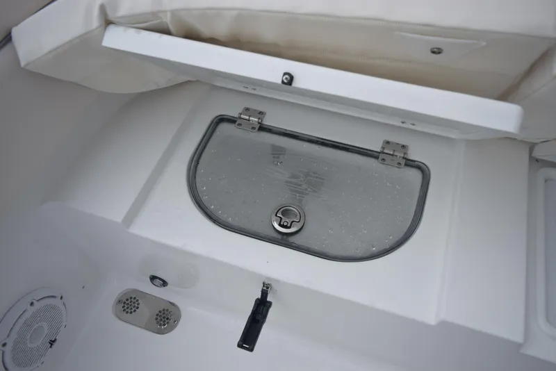 Slide: The Image of 2024 Sea Hunt Escape 27 boat storage compartment with transparent lid and latch. - 27
