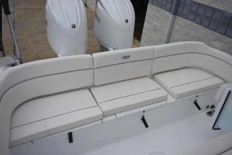 Slide: The Image of 2024 Sea Hunt Escape 27 boat with white cushioned seating and twin outboard motors. - 9