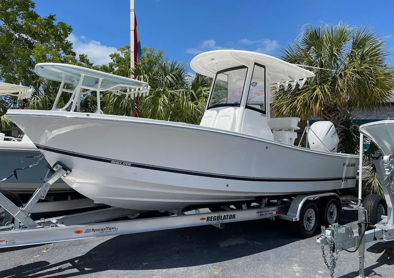 The Image of 2024 Regulator 24XO boat on a trailer, parked outdoors with palm trees in the background. - 0