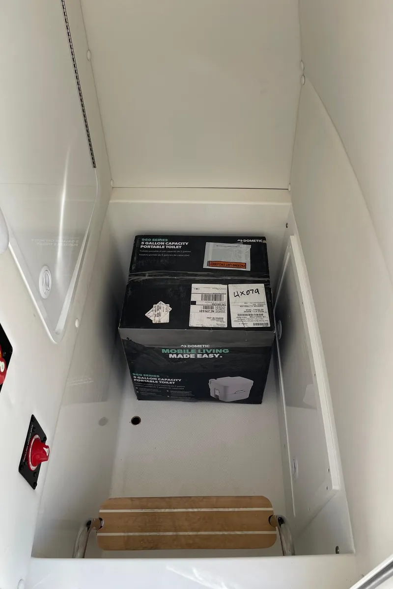 Slide: The Image of Storage compartment of 2024 Regulator 24XO boat with a box of heavy-duty trash bags. - 18