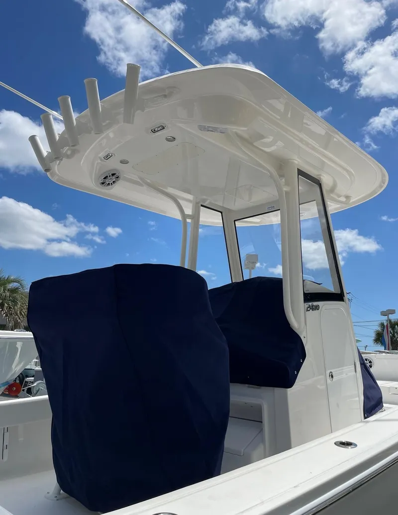 Slide: The Image of 2024 Regulator 24XO boat with covered seats and T-top under a blue sky. - 22