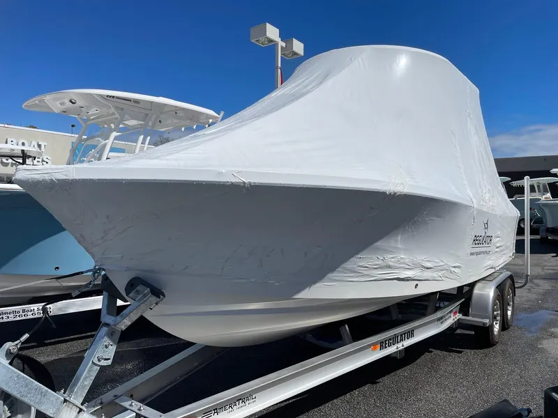 Slide: The Image of 2024 Regulator 24XO boat covered on a trailer in a dealership lot. - 25