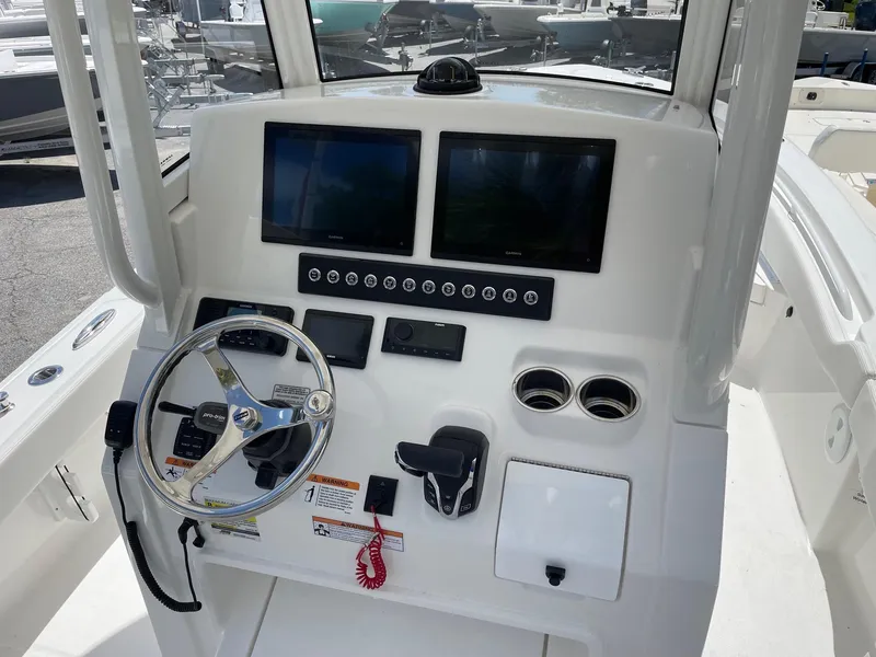 Slide: The Image of 2024 Regulator 24XO boat dashboard with dual screens, steering wheel, and controls. - 6