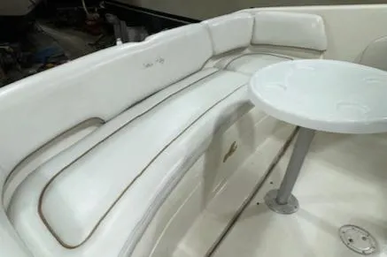 Slide: The Image of 1997 Sea Ray 280 boat interior with white seating and table. - 12