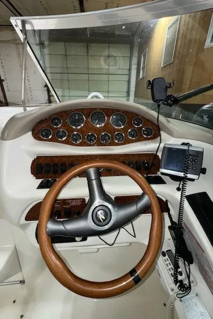 Slide: The Image of 1997 Sea Ray 280 boat dashboard with wooden steering wheel and instrument panel. - 21