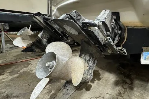 Slide: The Image of 1997 Sea Ray 280 boat propellers and stern drive in a workshop. - 32