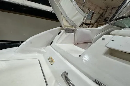 Slide: The Image of 1997 Sea Ray 280 boat interior with white seating and storage compartment. - 34