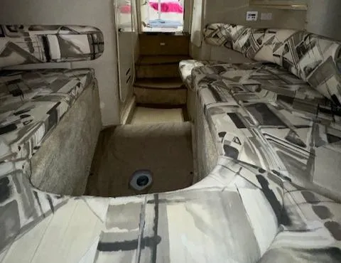 Slide: The Image of 1997 Sea Ray 280 boat interior with patterned seating and carpeted flooring. - 43